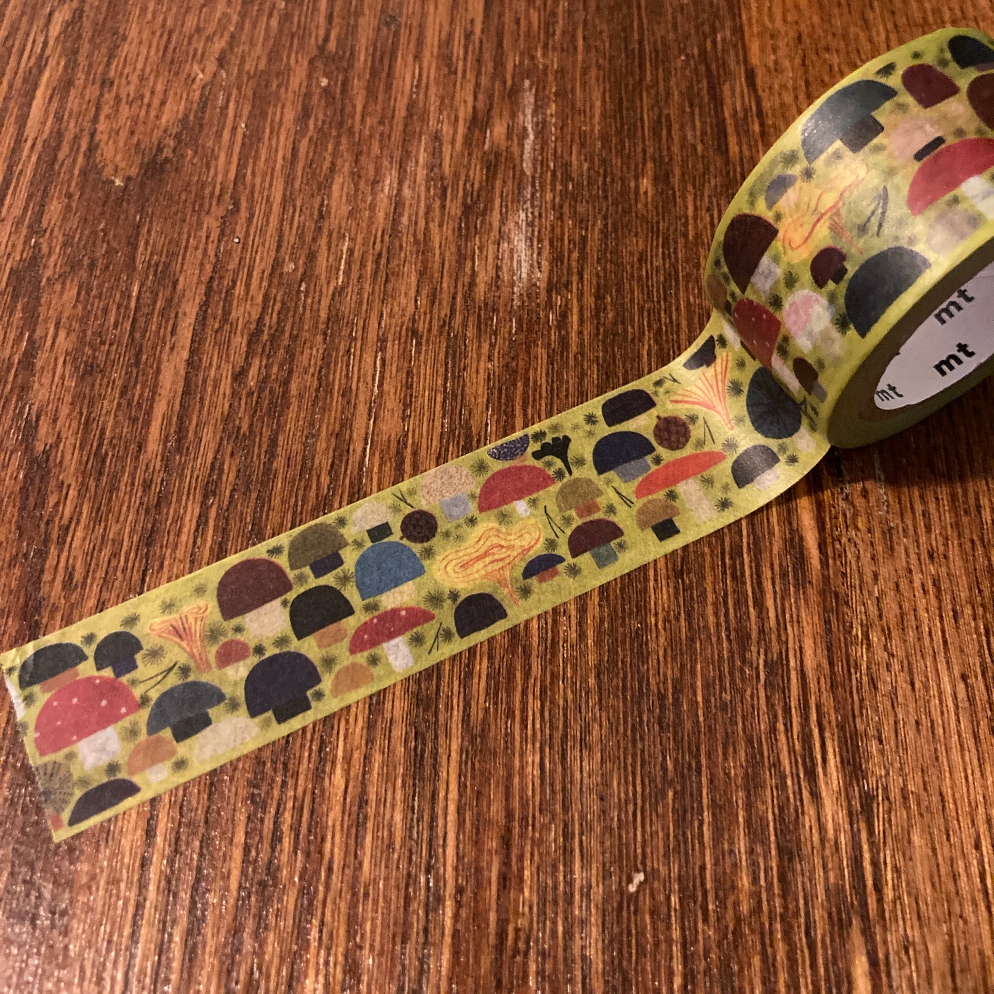 Washi tape with a green background and various shapes and sizes of mushroom all in bold colors.  